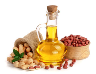 Wall Mural - peanut oil in a glass bottle with peanuts in bowl