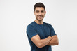 © Damir Khabirov - Portrait of attractive young sporty male in blue t-shirt standing with crossed arms isolated on gray background
