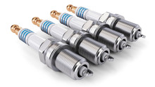 Four Spark Plugs Arranged In A Row On A White Background