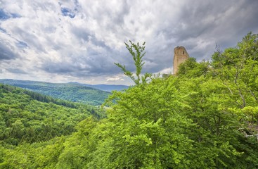 Wall Mural - Ruins of medieval Chojnik castle situated on the top of high hill covered with forest against cloudy sky in Jelenia Gora, Poland