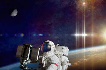 Wall Mural - astronaut taking selfie photo in space on orbit of planet earth