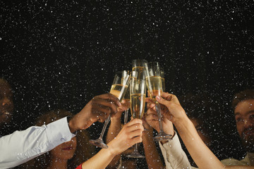 group of young people celebrating new year with champagne at night club