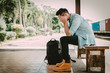 © interstid - Depressed Asian traveler man waiting at train station after miss a train or delay