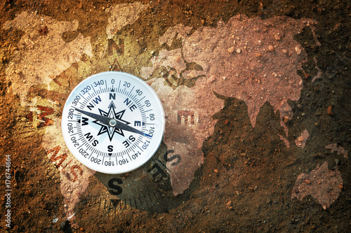 Plakat Kompas i mapa świata na suchej ziemi, płaski widok z góry, Znajdź właściwą drogę dla naszej koncepcji ziemi