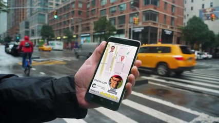 A man uses a ride-sharing app on his cellular phone to call a driver.	 	