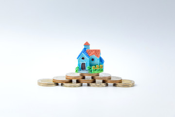 Concept for property ladder, mortgage and real estate investment. house modell on top of coins stack