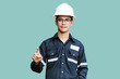 © Goodvibes Photo - Asian man,Engineer or Technician in white helmet, glasses and blue working shirt suit Pointing the finger, isolated on white, mechanic and Oil and Gas industrial concept with clipping path