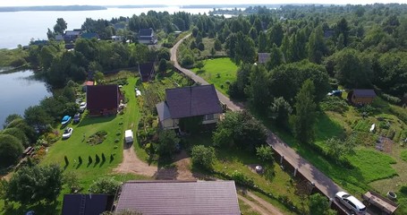 Wall Mural - The dirt road goes to asphalt in the Russian village, the car rides along the road. Aerial view