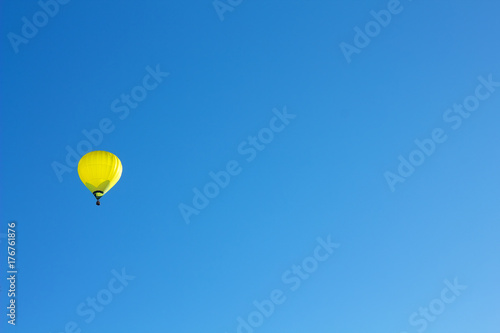 Plakat Żółty gorącego powietrza ballon na niebieskim niebie.