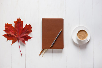 Wall Mural - the concept of autumn mood and inspiration. morning coffee, diary and colored maple leaves.top view