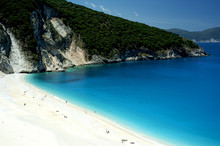 Sunbathers On The Bone-white Sands Of Kefalonia's Myrtos Beach Considered One Of The Most Beautiful In All The Greek Islands.