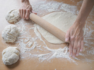 Female hands making dough for pizza
