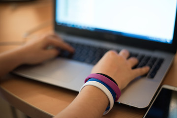 Close-up view of boy hands working on a laptop