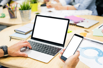 Man working on laptop and mobile phone