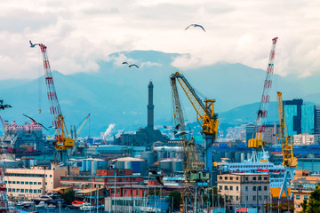 Genoa's lantern and industrial port with cranes.