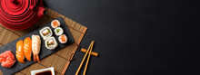 Set Of Sushi With Wasabi, Soy Sauce And Teapot On Black Stone Background