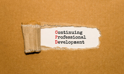 Wall Mural - The text Continuing Professional Development appearing behind torn brown paper