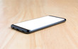 © ukimurakung - Black smart phone with white screen on the wooden table