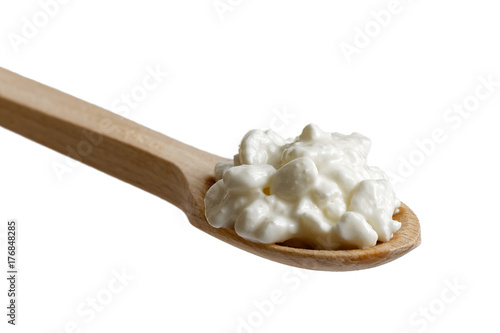 Zdjęcie XXL Klockowaty chałupa ser na drewnianej łyżce odizolowywającej na bielu.