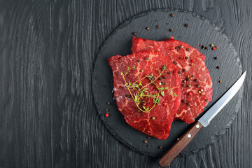 Poster - two raw marbled beef steaks on black