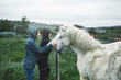 Travel to Iceland. a woman stroking a horse in the field