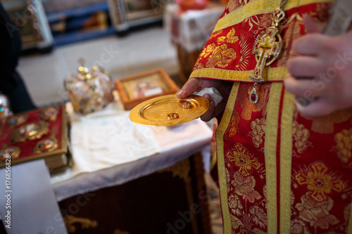 Zdjęcie XXL ksiądz trzyma złotą obrączkę na ślub para