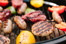 Meat And Vegetables Being Grilled On A Charcoal Barbecue Outdoors