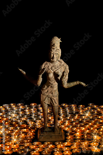 Plakat Diwali. Tradycyjny brązowy posąg hinduskiej bogini Lakshmi lub Laxmi w płonącym świetle świec.