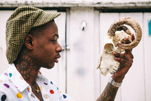 Tattooed Man Holding Rams Skull