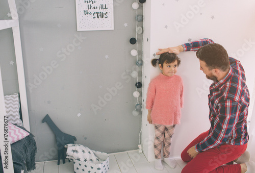 Fotografía Father is measuring his baby height on the wall