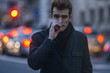 © Igor Madjinca/Stocksy - evening city atmosphere,young man smokes a cigar on the city street