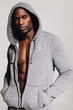 © Jacob Lund/Stocksy - Muscular man in hooded sweatshirt looking away in thought