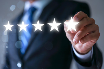 Wall Mural - Businessman pointing five star symbol to increase rating of company