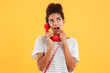© Drobot Dean - Smiling young lady holding red handset isolated
