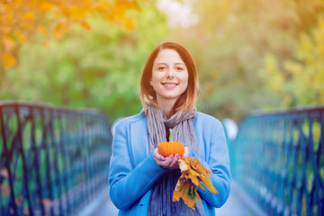 Sticker - woman holding yellow maple tree leaves and pumkin in autum park