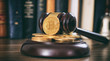 Judge or auction gavel and bitcoins on a wooden desk