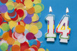 Number 14 celebration candle with party confetti