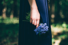 Hand Holding Sheaf Of Blue Flowers