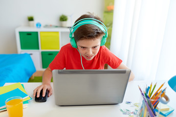 Wall Mural - boy in headphones playing video game on laptop