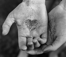 Two Hands Gently Holding A Glitter Heart