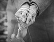© dzmitrock87 - child's hand reaches out to the rope-tied hands of the parent. Black and white image. Woman's hands tied with rope. Violence in family concept.