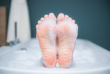 Closeup Of Woman's Foot On The Edge Of A Bath With Foam