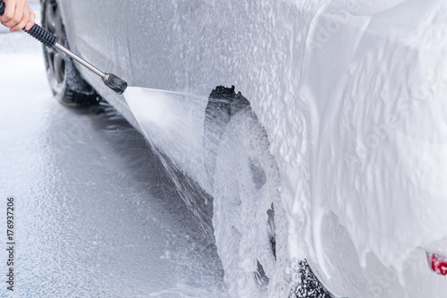 Fotografia, Obraz Applying non-contact foam to a car from a gun to a car wash