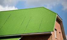 Green Roof On The House Against The Blue Sky