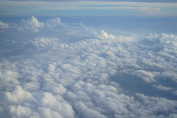 Wall Mural - view of beautiful wide wonderland cloudscape with shades of blue sky background from flying plane wi