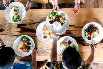 Top view of people having dinner together on wooden table