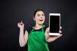 © Catalin Pop - Smiling supermarket female employee showing smartphone