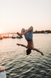 © Josh - Young boy backflips off wharf into water