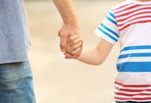 Boy Holding Father's Hand Outdoors