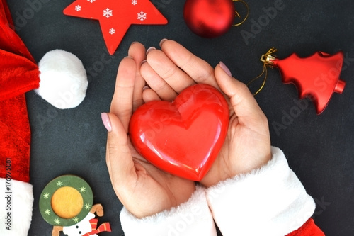 Zdjęcie XXL Zakończenie up Santa ręki trzyma czerwonego kierowego kształt na Bożenarodzeniowym tle